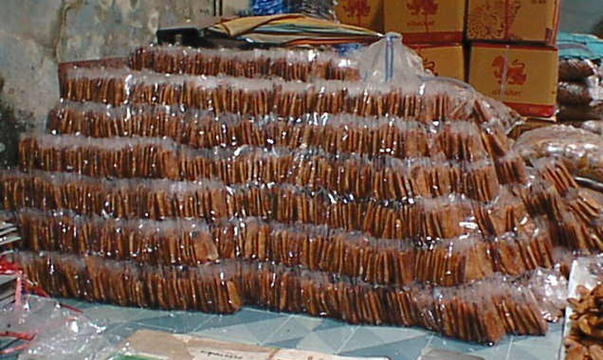 Large stacks of individually packaged dried bananas, representing primary food processing, in Ban Bang Krathum, Thailand. The bananas are arranged in clear plastic bags.