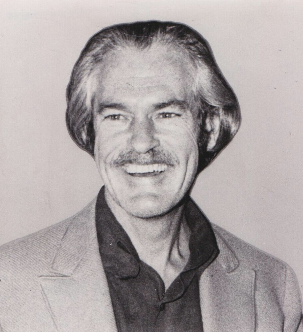 A black and white AP Photo of Dr. Timothy Leary from 1970, showing him smiling with a mustache and a collared shirt under a jacket.