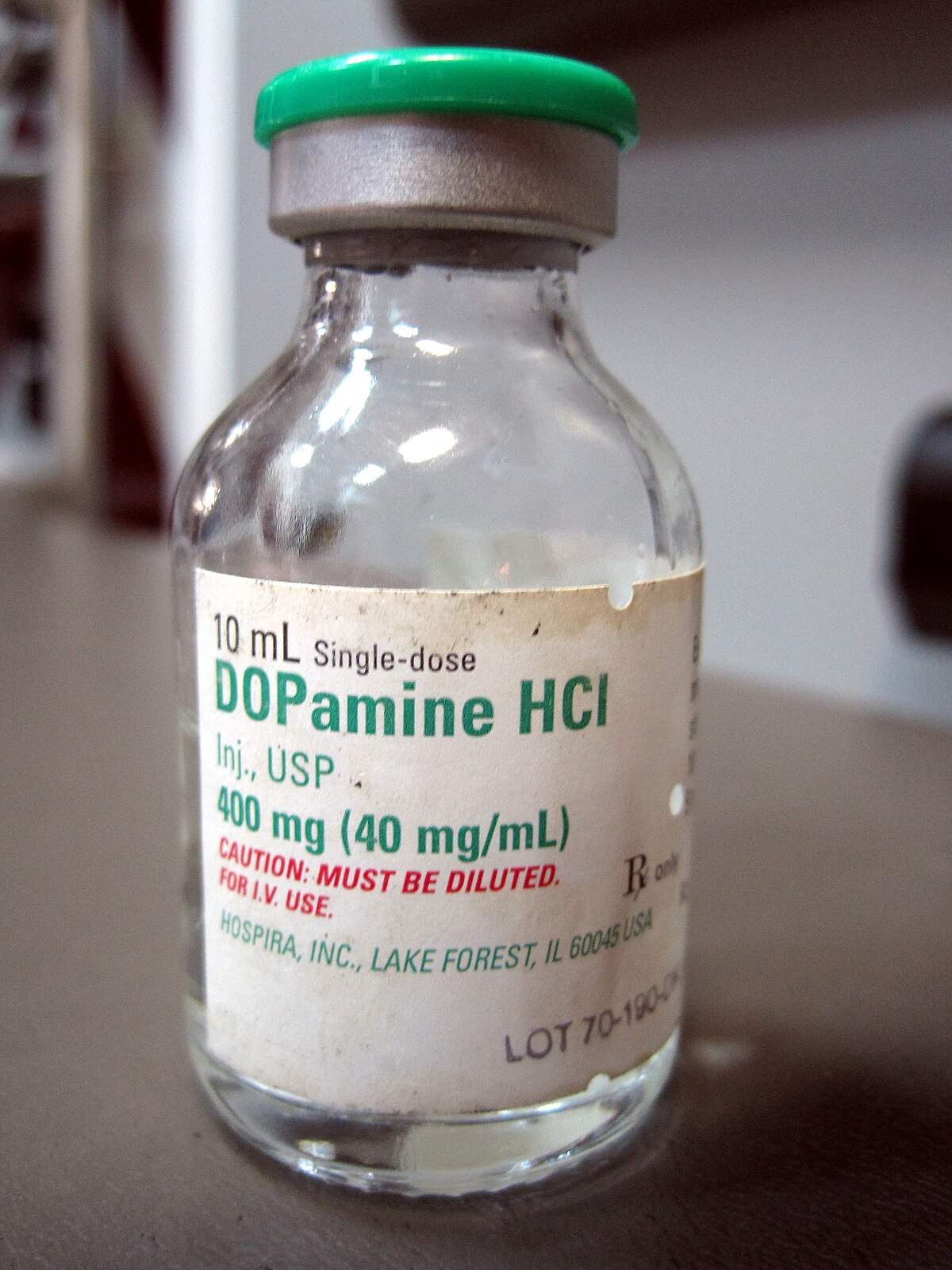 Glass vial containing Dopamine HCl preparation for intravenous administration. The label indicates "10 mL Single-dose DOPamine HCl Inj, USP, 400 mg (40 mg/mL)" and a caution to "MUST BE DILUTED."
