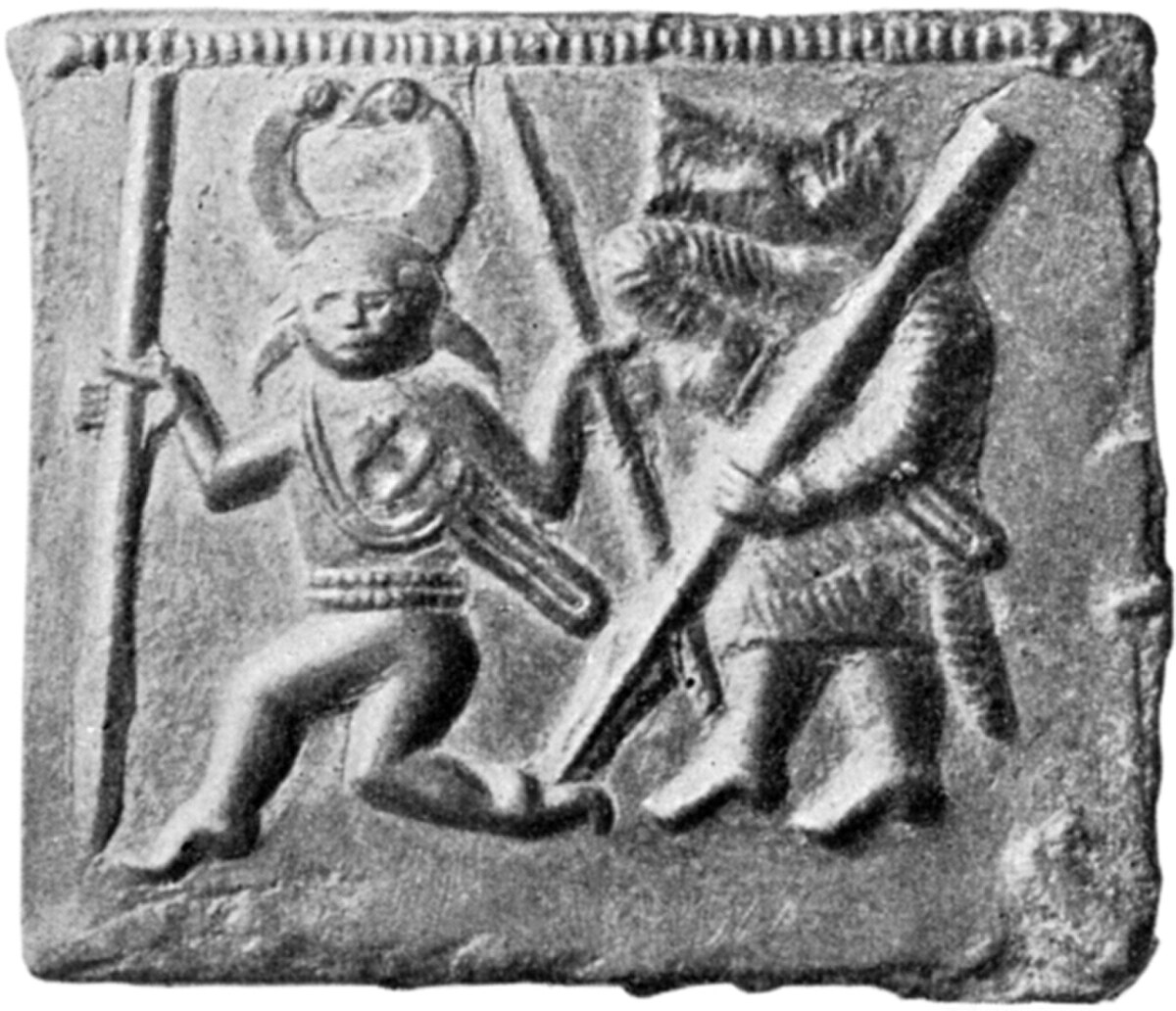 One of the Torslunda plates, depicting two figures in a relief. The figure on the left, with a horned helmet, was originally cast with two eyes, but the right eye was later removed, while the figure on the right holds a large staff or weapon.