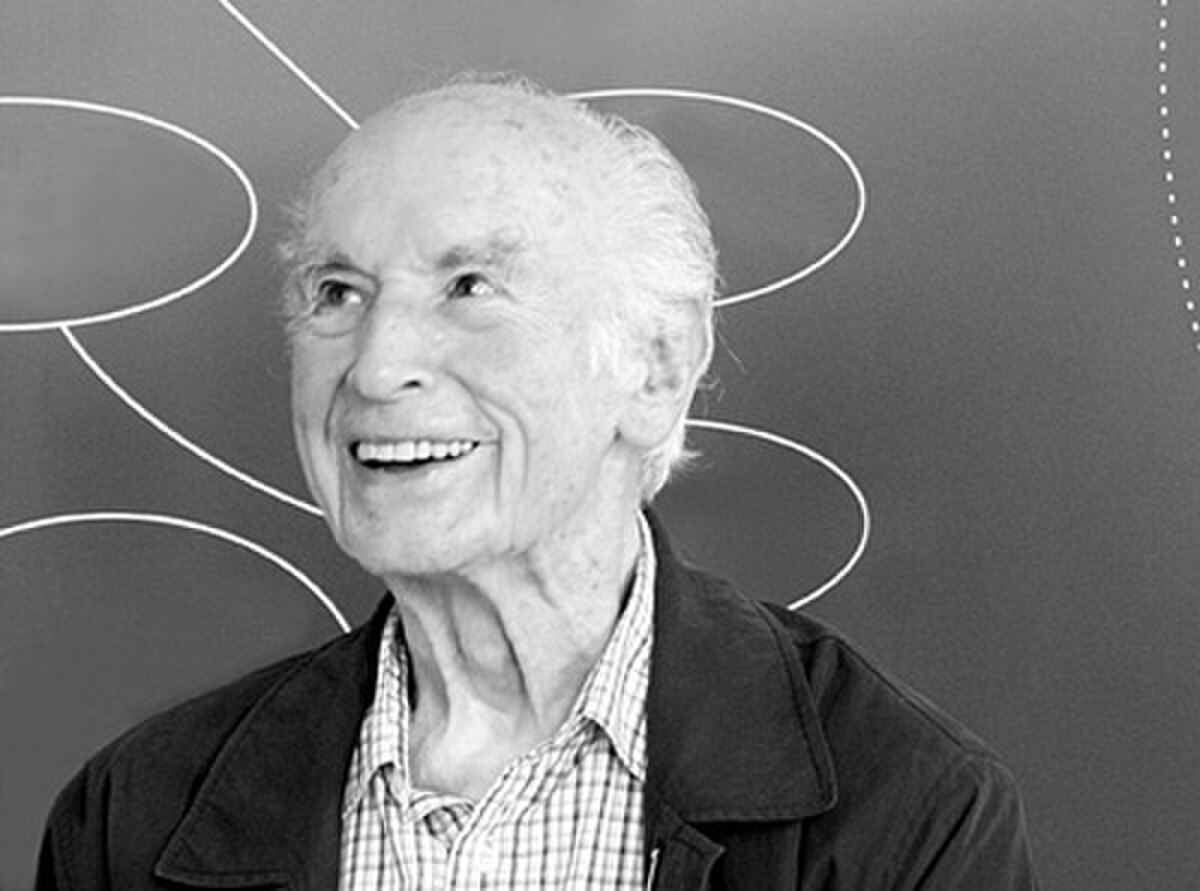 Black and white portrait of Albert Hofmann, a man with white hair, smiling and looking to the side. The image was taken in 2006.