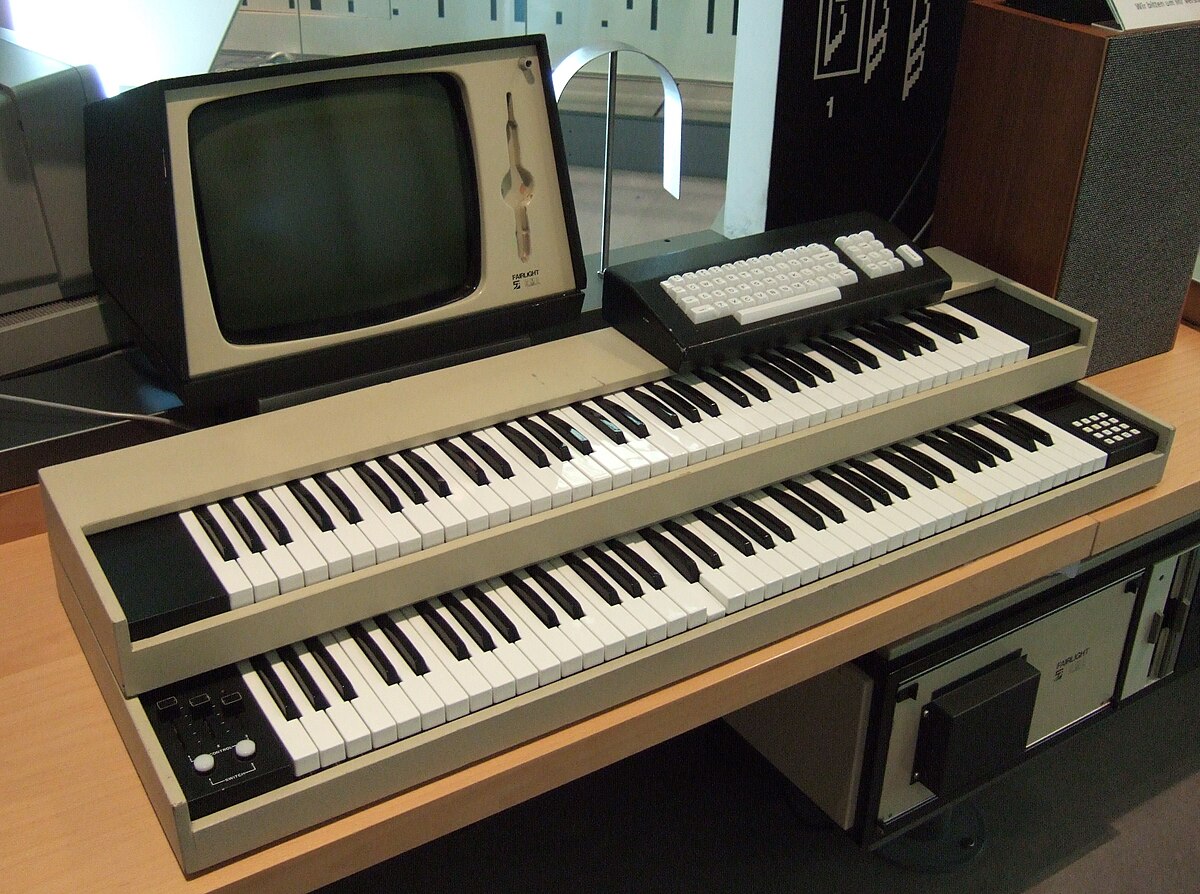 The Fairlight CMI, a sampler and synthesizer released in 1979, featuring two keyboards, a monitor, and a separate computer unit. The monitor displays a green waveform, and the instrument has various buttons and sliders.