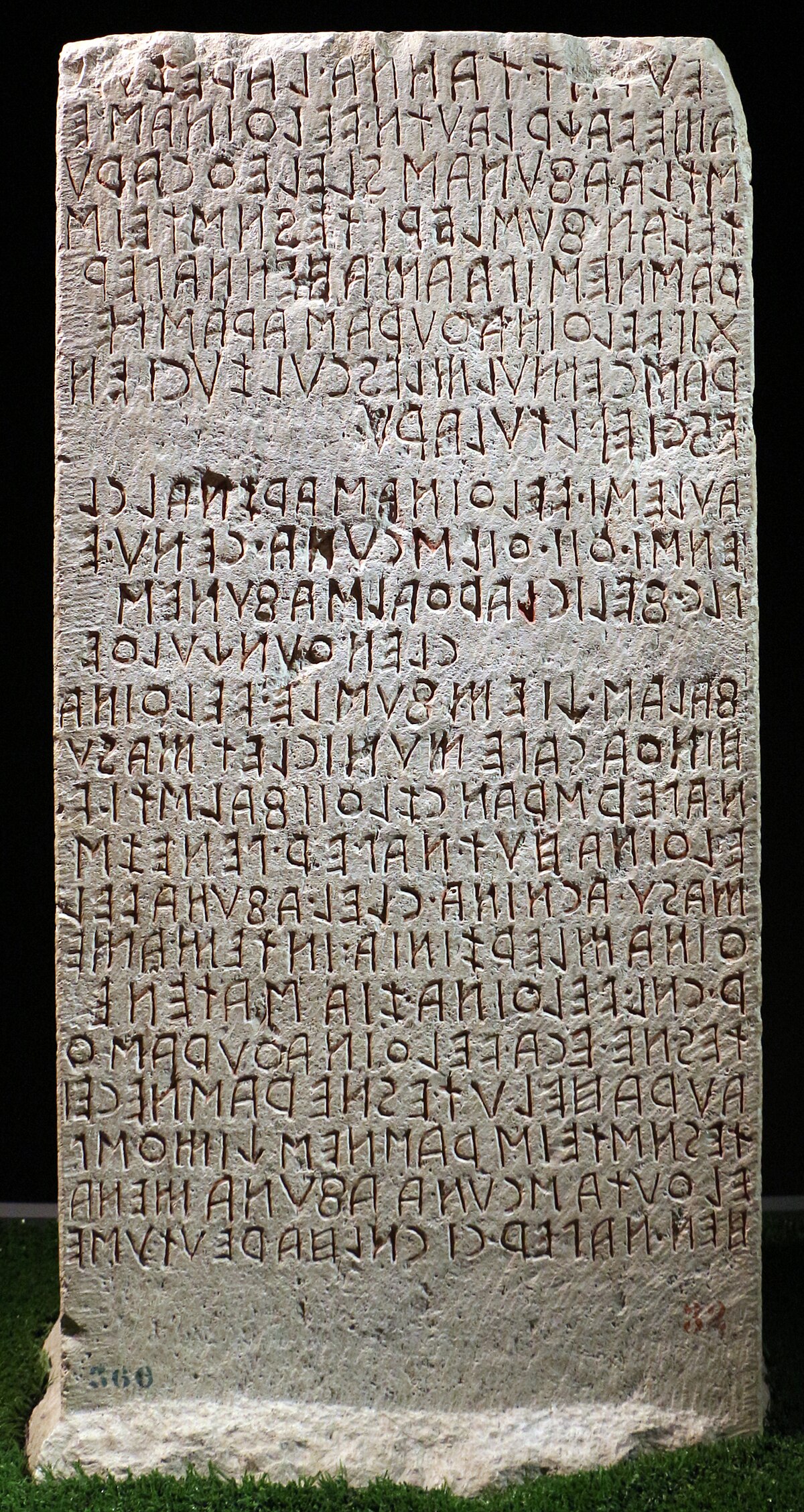 The Cippus Perusinus, an Etruscan stone tablet with a long inscription in the Etruscan language, detailing a legal agreement between the Velthina and Afuna families. The text is carved vertically in multiple lines on the rectangular stone.