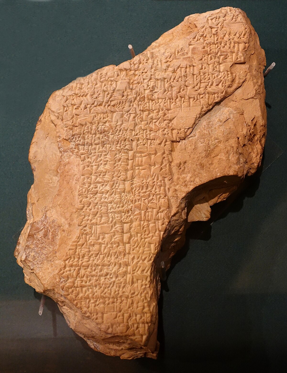 A Sumerian clay tablet inscribed with cuneiform script, housed in the Oriental Institute Museum at the University of Chicago. The tablet is irregularly shaped and contains dense rows of ancient writing.