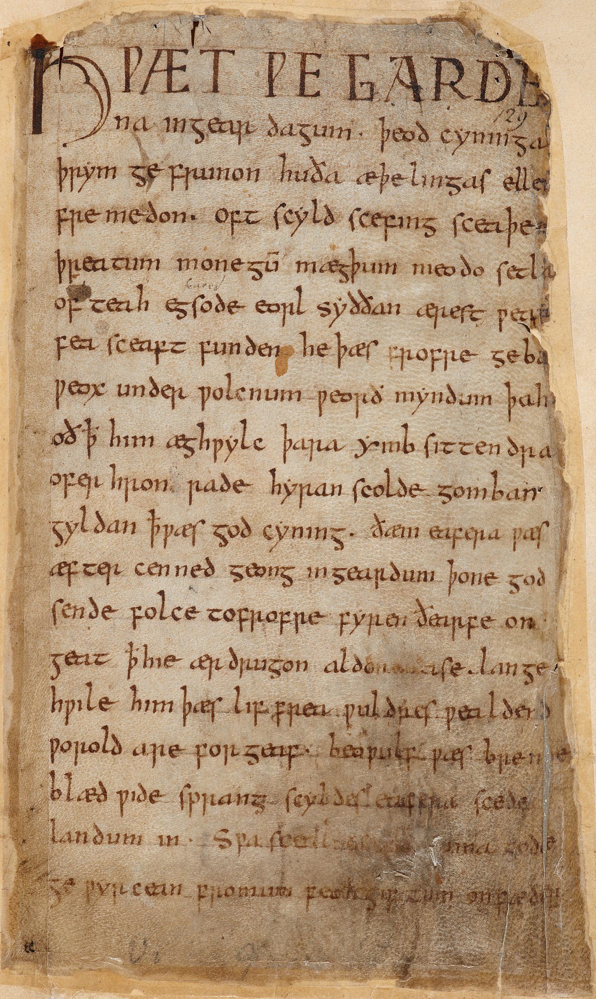 The first page of the Beowulf manuscript, Cotton MS Vitellius A XV, f. 132r, featuring Old English text in a medieval script. The page shows some signs of damage and discoloration, with the text written in dark ink.