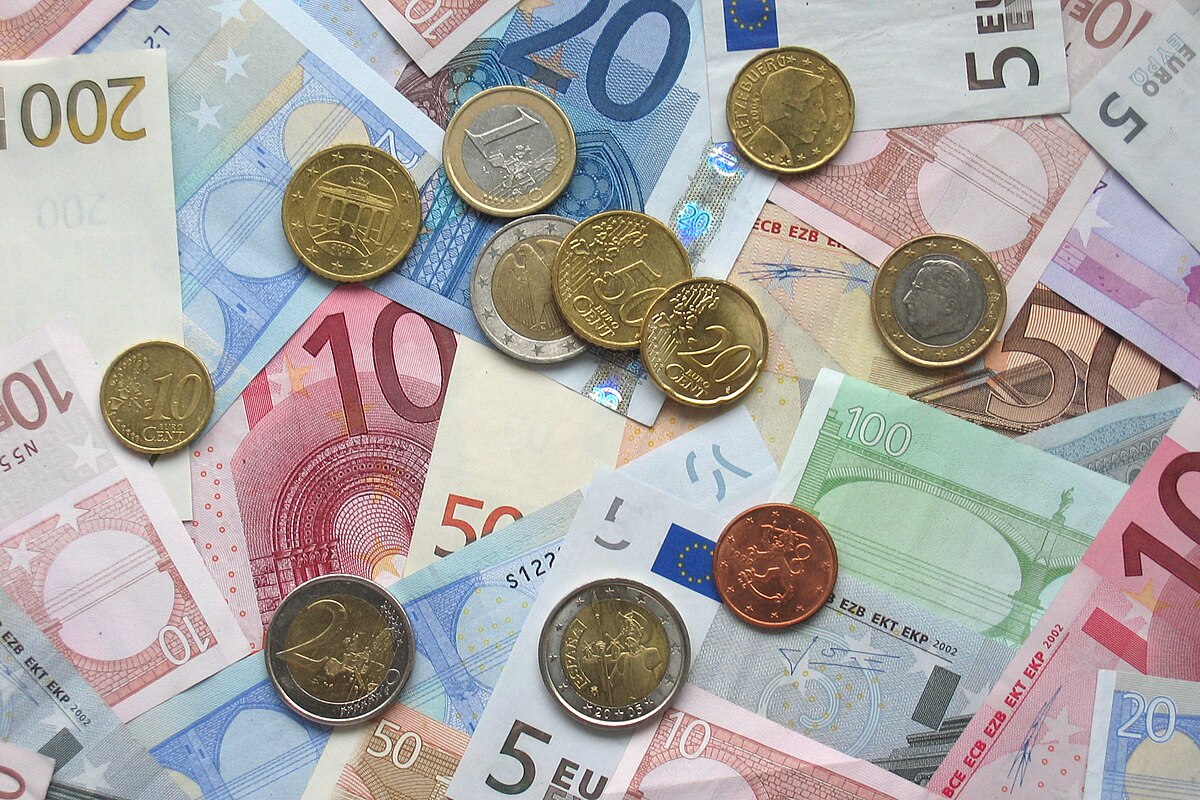 A scattered arrangement of various Euro banknotes and coins, including denominations such as 5, 10, 20, 50, 100, and 200 Euro notes, and 1, 2, 5, 10, 20, 50 cent, 1 Euro, and 2 Euro coins.
