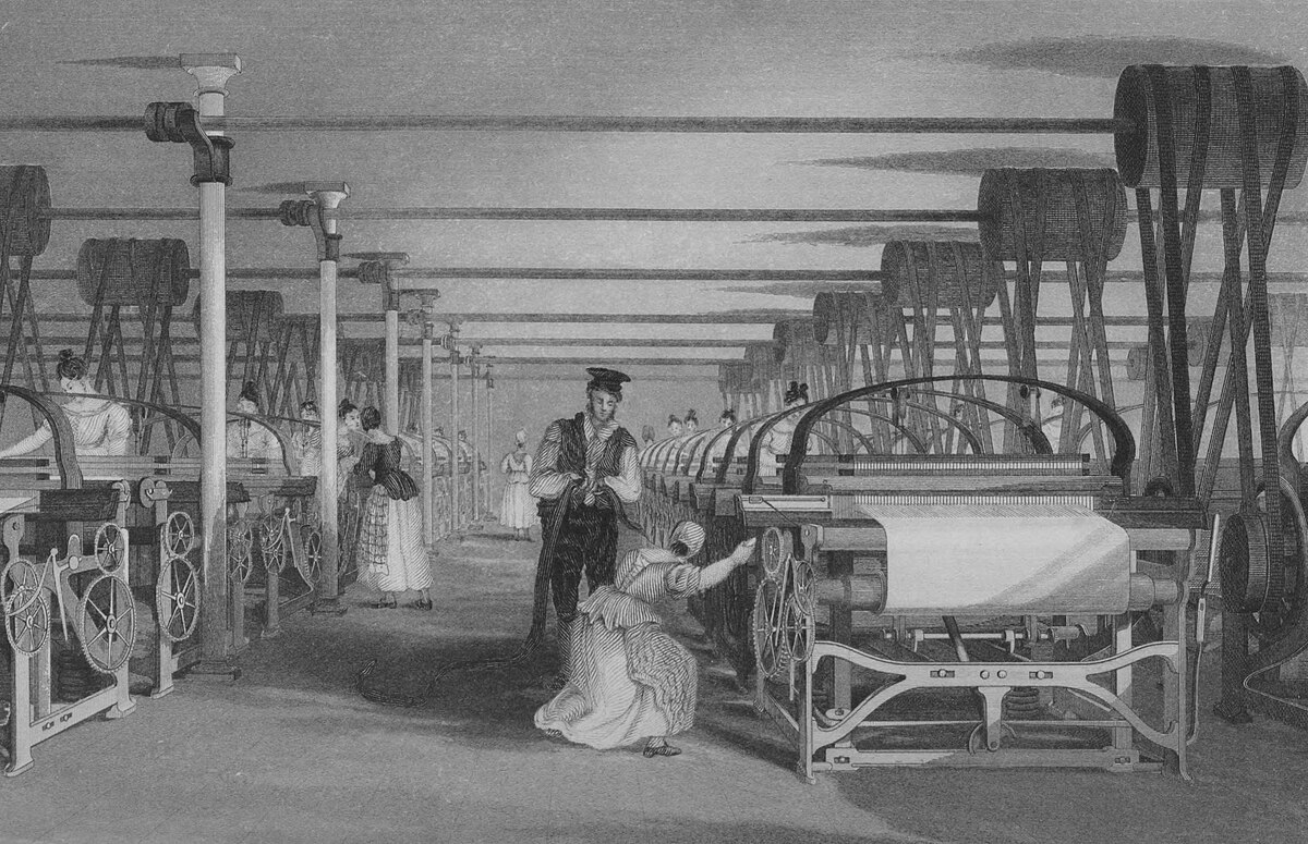 An engraving depicting a weaving shed in the United Kingdom in 1835, showing multiple Roberts looms in operation with workers attending to them. The scene illustrates the industrialization of textile production during the Industrial Revolution.