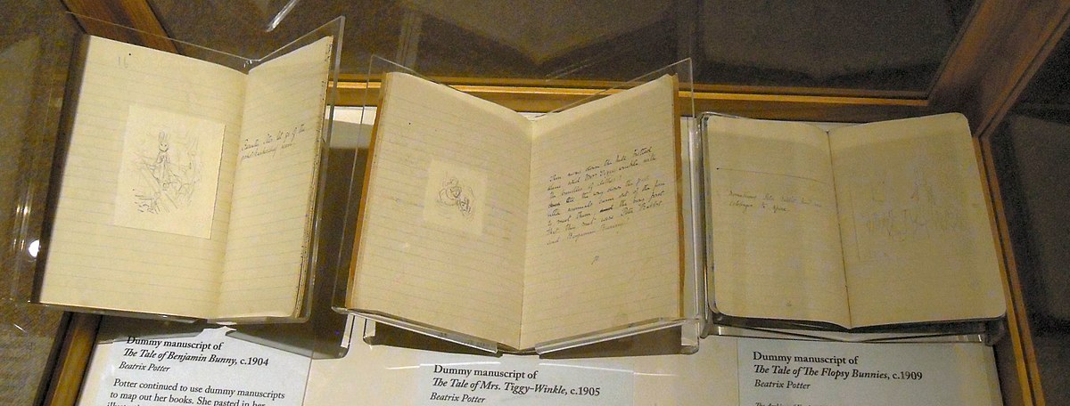 Three of Beatrix Potter's dummy manuscripts are displayed, open to show handwritten text and small illustrations. The labels beneath identify them as "Dummy manuscript of The Tale of Benjamin Bunny, c.1904," "Dummy manuscript of The Tale of Mrs. Tiggy-Winkle, c.1905," and "Dummy manuscript of The Tale of the Flopsy Bunnies, c.1909."