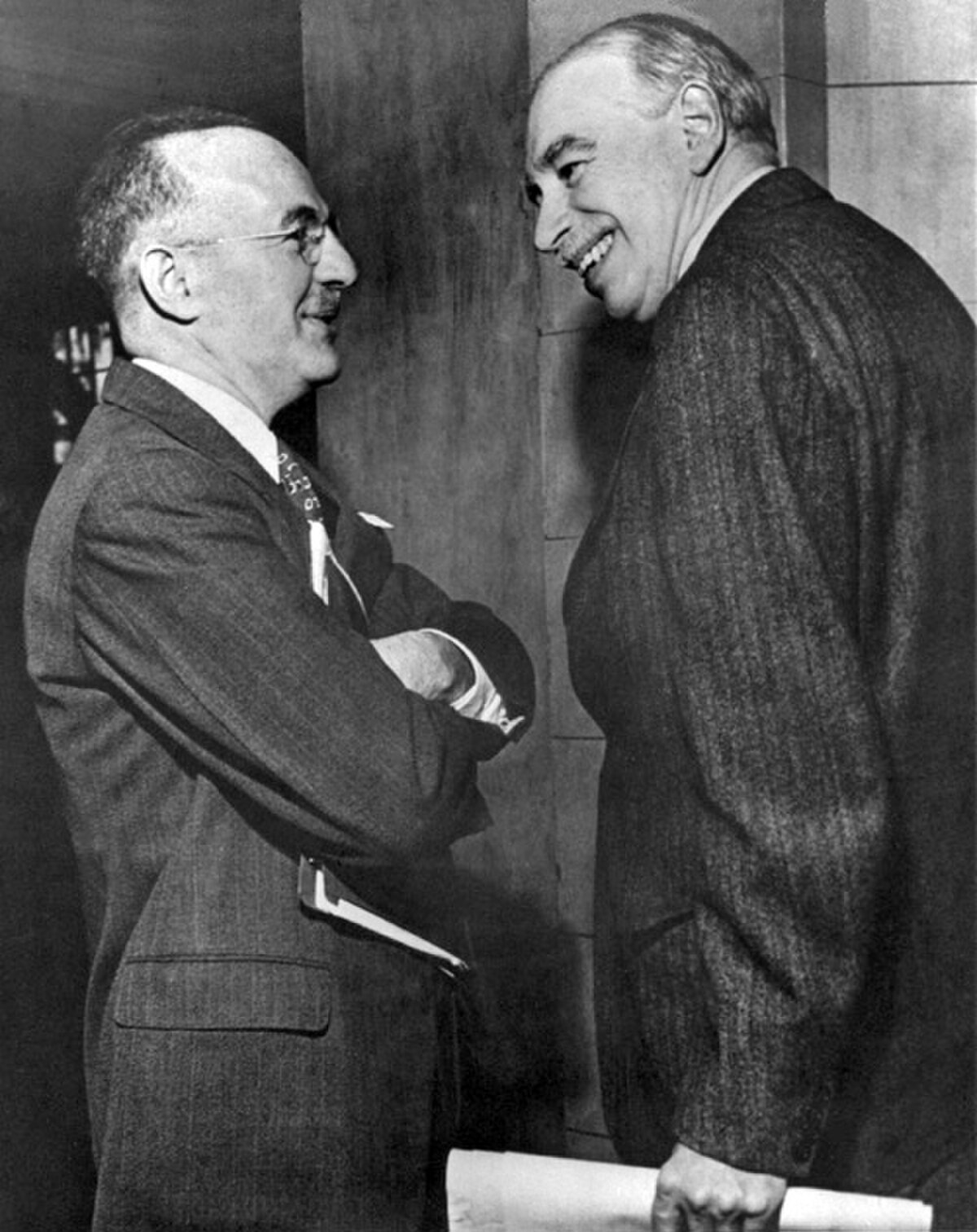 John Maynard Keynes (right) and Harry Dexter White at the inaugural meeting of the International Monetary Fund in 1946, engaged in conversation. Both men are dressed in suits.
