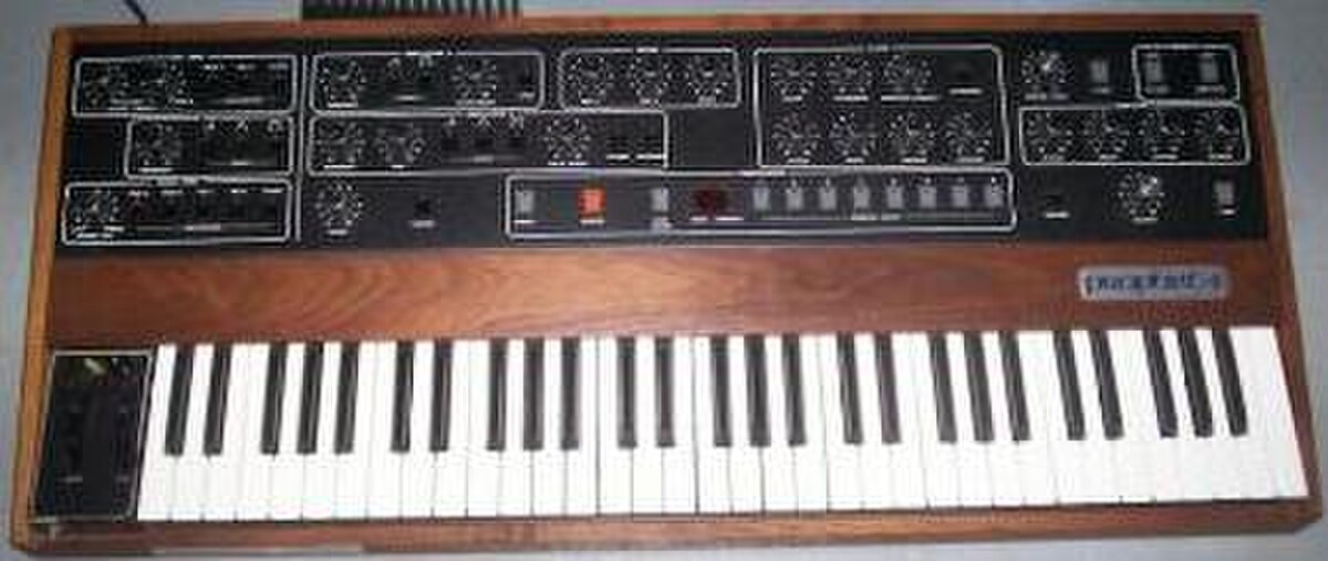 The Sequential Circuits Prophet-5 synthesizer, a polyphonic synthesizer with a wooden casing, a keyboard, and numerous knobs and buttons for sound control. It was widely used in 1980s synth-pop.