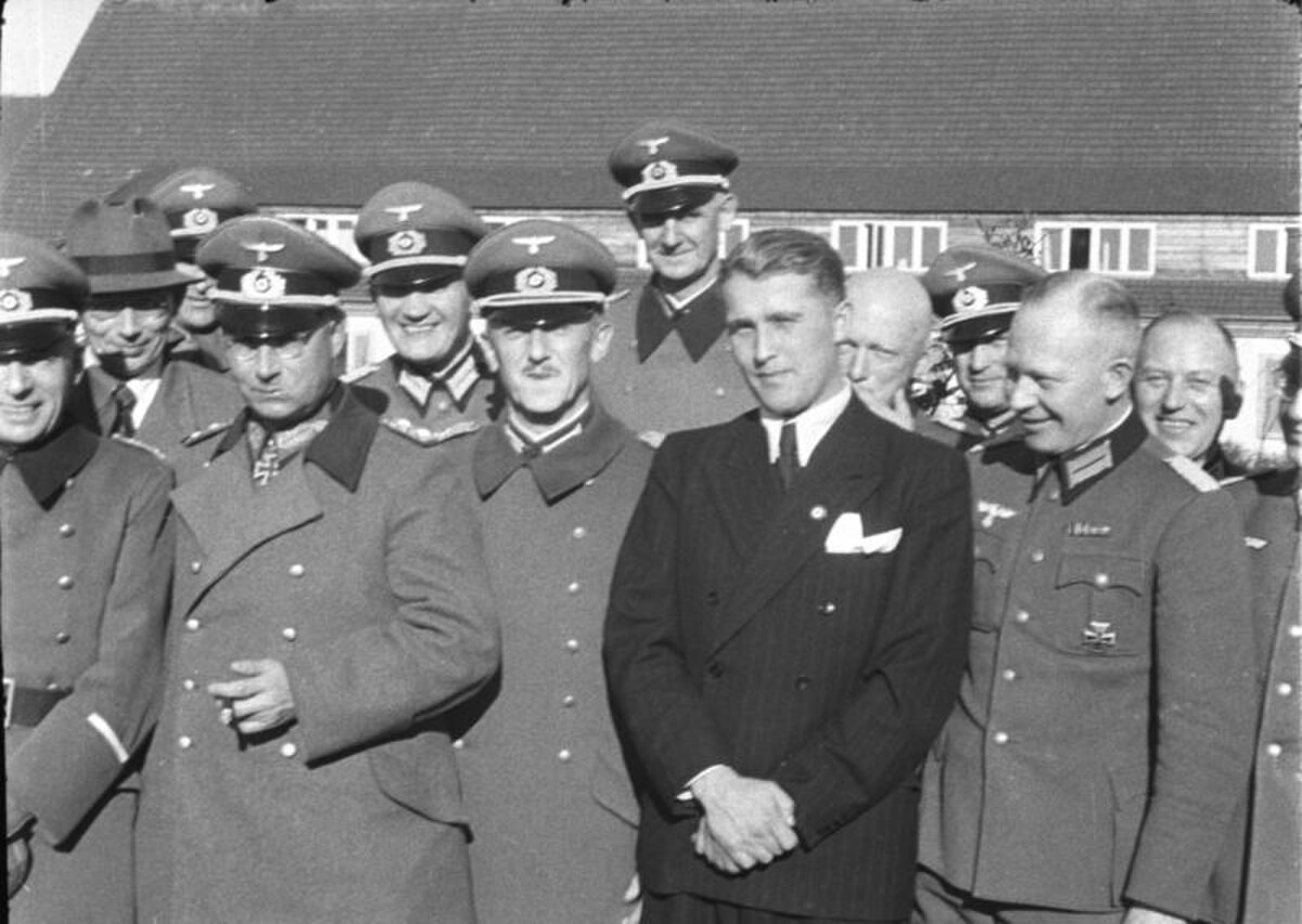 A black and white photograph from March 1941 at Peenemünde shows a group of German military officers and Wernher von Braun. From left to right in the first rank are General Walter Dornberger (partially hidden), General Friedrich Olbricht (wearing a Knight's Cross), Major Heinz Brandt, and Wernher von Braun (in civilian dress).