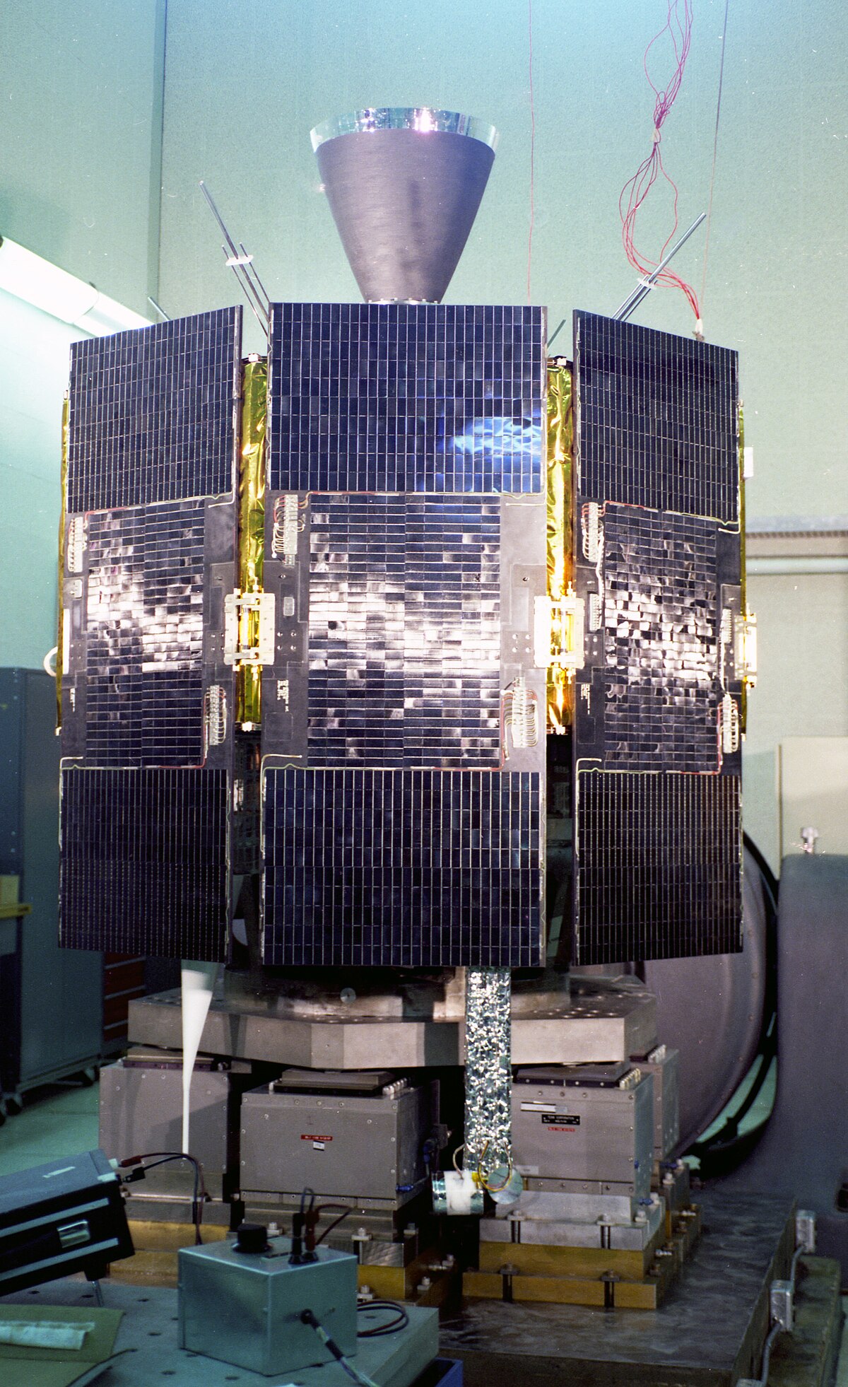 The Navigation Technology Satellite, II (NTS-II), also known as Timation IV, is shown in a laboratory setting. This satellite, launched on June 23, 1977, was the first completely designed and built by NRL under GPS Joint Program funding, featuring multiple solar panels.