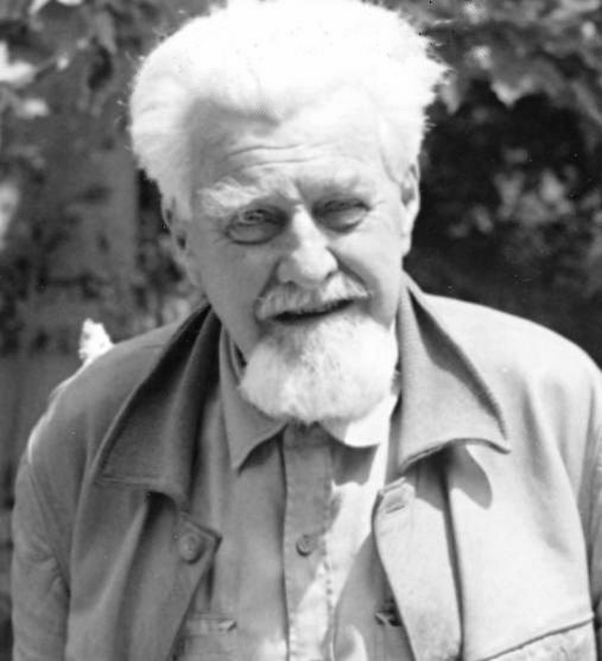 Portrait of Konrad Lorenz, an Austrian zoologist, ethologist, and ornithologist, known for his work on imprinting. He is shown with white hair and a white beard, wearing a light-colored collared shirt and jacket.