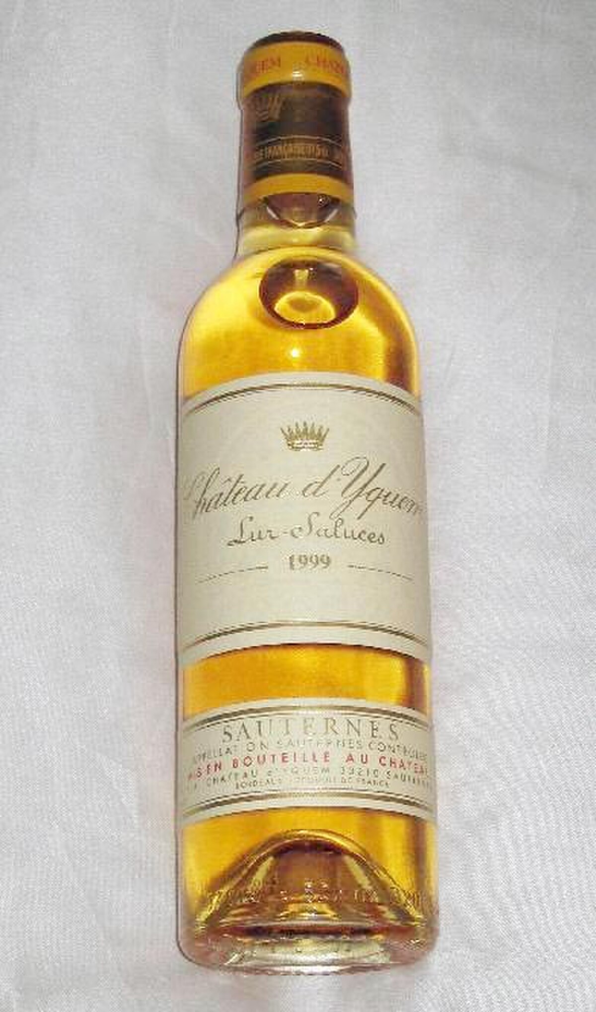 A bottle of Château d'Yquem 1999, a dessert wine from Sauternes. The label features a crown and the text "Château d'Yquem", "Lur-Saluces", "1999", and "SAUTERNES".